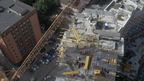Builders and crane working on Unfinished Residential Building Construction Site Stock Footage 98699619
