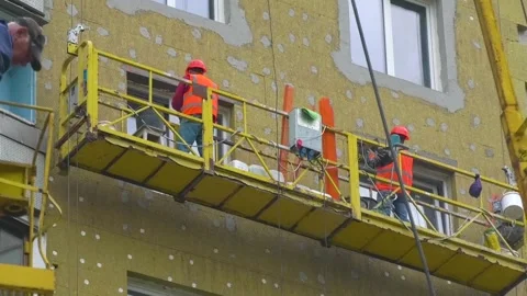 Builders are carrying out work on insulating the facade of the house 動画素材 346804732