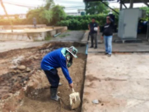 Builders are digging the ground to prepare the site for concrete road const.. Stock Photos
