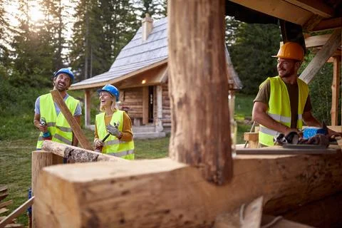 Builders are in a good mood while working at the cottage construction site .. Stock Photos
