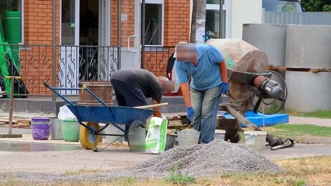 Builders are kneading a concrete solution with a concrete mixer. Video stock 111911163