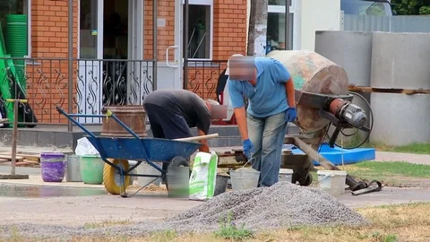 Builders are kneading a concrete solution with a concrete mixer. Video stock 111977298