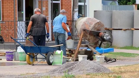 Builders are kneading a concrete solution with a concrete mixer. Video stock 113217642
