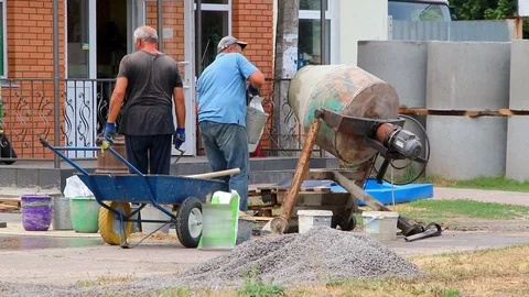 Builders are kneading a concrete solution with a concrete mixer. Video stock 113412219