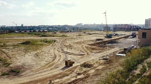 Builders are working on a new building on an unfinished large area Stock Footage 137949150