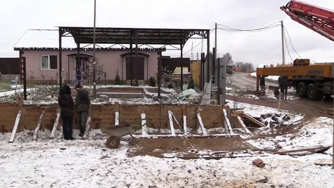 Builders build concrete retaining wall in formwork on country land plot Stock Footage 83504396
