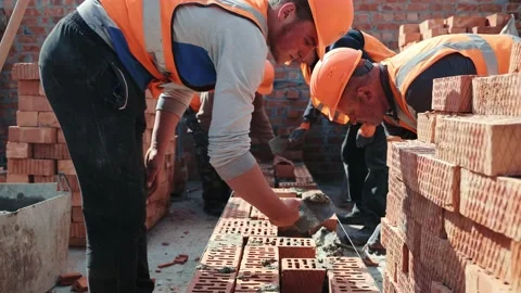 Builders building a brick wall. Construction work on construction. The masters Video stock 155901405