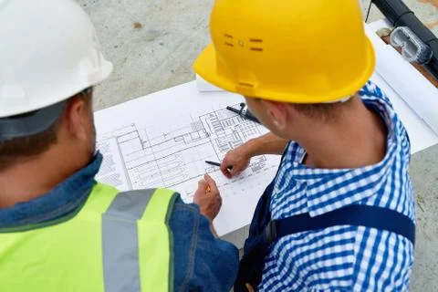 Builders Checking Floor Plans on Site 写真素材