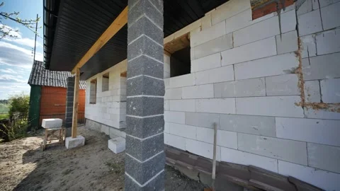 Builders constructing walls of aerated concrete blocks in slavic village Stock Footage 312897724
