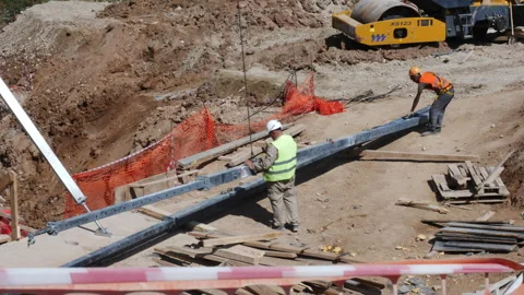 Builders control lifting of long metal beam with crane hoist Stock Footage 249182118