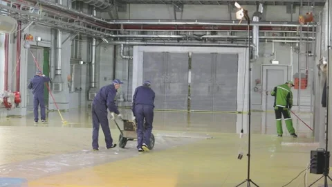 Builders create a self-leveling floor. The builders do the work inside. Creation Stock Footage 243264225