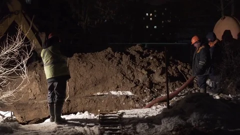 The builders digging a hole during the night shift Stock Footage 72450150