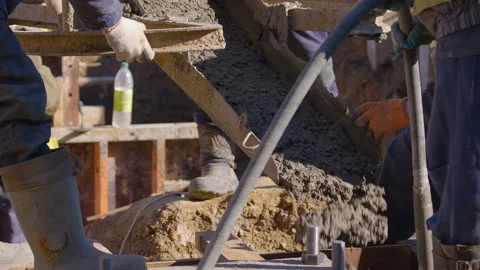Builders direct concrete from the bucket to the column bases Stock Footage 147633340