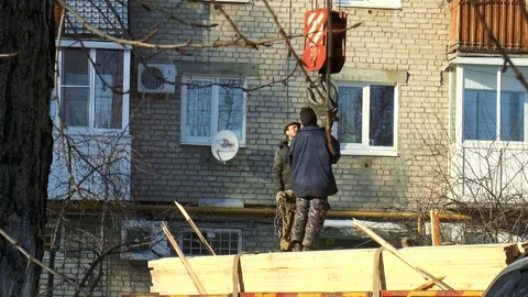 Builders fasten the boards to the crane hook Stock Footage 86649996
