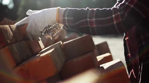 Builder's hands are stacking red bricks in a large warehouse. Pile of buildi Stock Footage 196977358