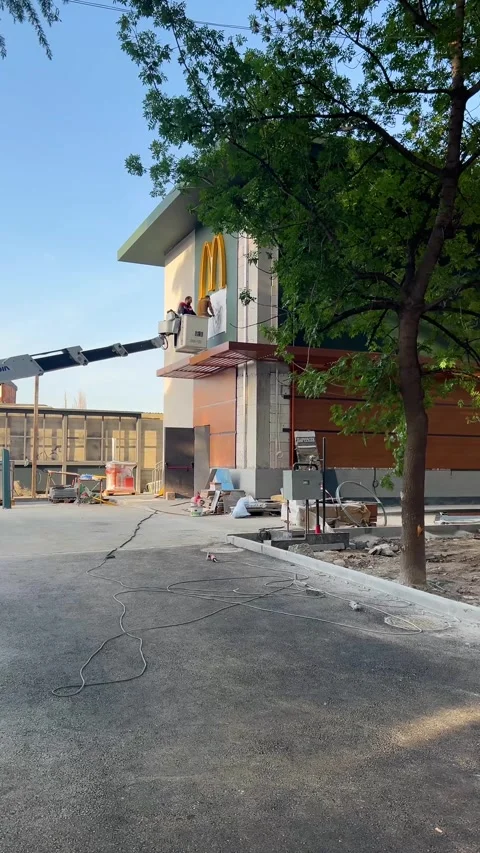 Builders hang logo of fast food restaurant McDonald Stock Footage 309964261