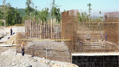 Builders in helmets reinforce the mesh and put the formwork before pouring Stock Footage 73803565