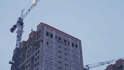 Builders hook a load onto a crane, after which they fool around wanting to throw Stock Footage 146101368