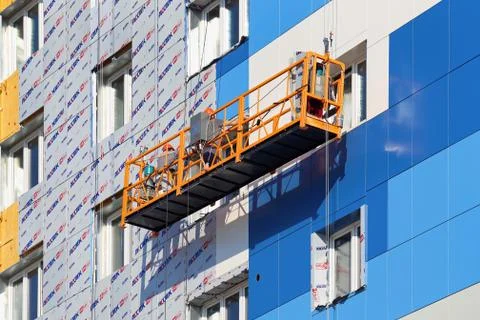 Builders install panels on the facade of a multi-storey building Fotos de archivo