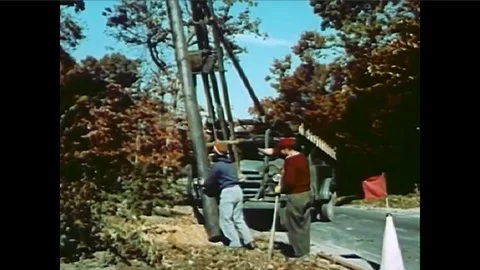 Builders install telephone poles and cables while accountants keep track of 库存影片 101200841