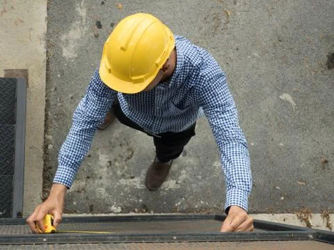Builders installing measuring container. Stock Photos
