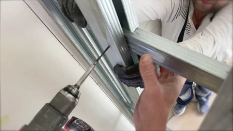 Builders installing metal construction profiles for assembling plasterboards Video stock 154605186