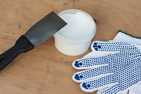 Builders kit, construction spatula, can of white putty, protective gloves Stock Photos