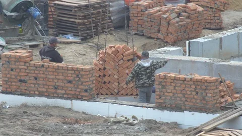 Builders lay a pallet with bricks on a construction crane on the ground Stock-Footage 120674026