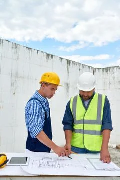 Builders Looking at Floor Plans on Construction Site 写真素材