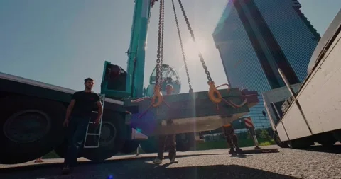 Builders move loads using a mobile truck crane. Lens flare. Video stock 136527200