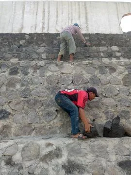 Builders moving stone from the ground up Stock Photos