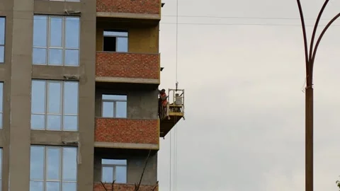  builders perform outdoor work, being on elevator at building site Stock-Footage 133135586