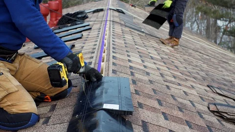 Builders on the roof attach soft tile and ridge. Frame house under construction Stock Footage 127756731