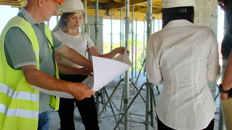 Builders study layout looking at sheet with building description Stock Footage 317607824