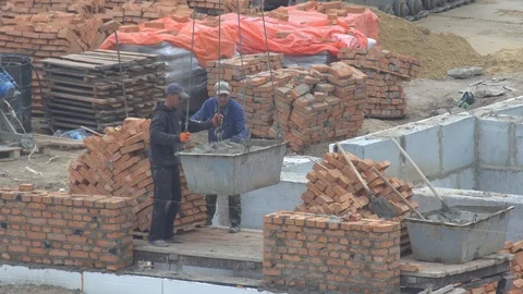 Builders take a container with cement. the crane lowers the cement mortar Stock Footage 120674503