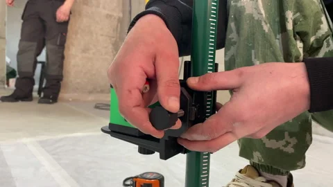 Builders team construction site worker turning on laser level device close up Stock Footage 150175275