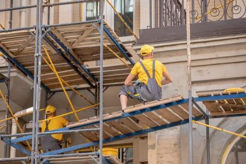 Builders in uniform work at a construction site. Stock Photos