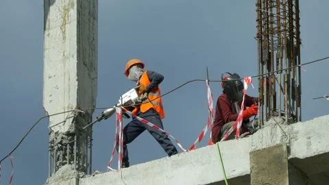 Builders work on a construction site with a jackhammer and electric welding. Stock Footage 196250398