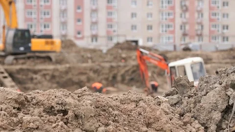 Builders work into large clay pit for construction Stock Footage