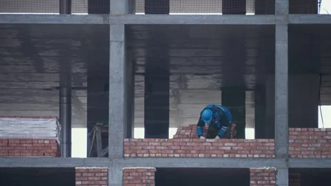 Builders work on scaffolding in uniform and safety helmets. Construction. Stock Footage 321004422