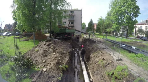 Builders working in the ditch on central heating pipes, time lapse 4K Stock Footage 60643721