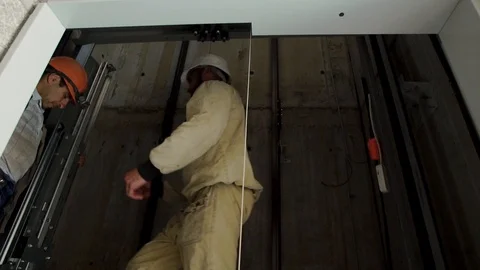 Builders working in the Elevator shaft. Workers install Elevator equipment 動画素材 93586639