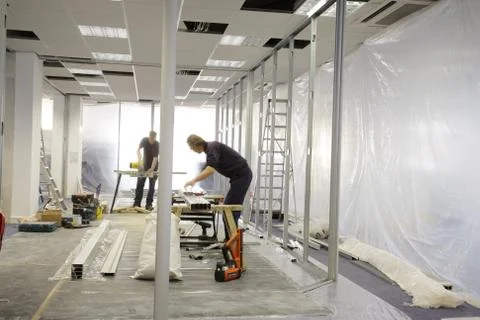 Builders working in an office Stock Photos