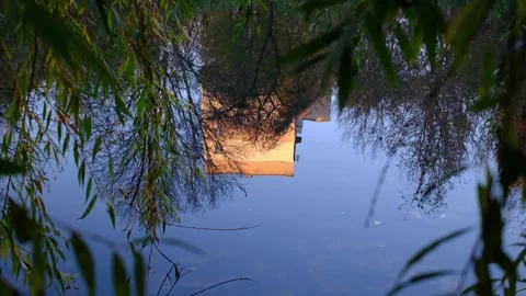 A building and bare trees reflect in water at Riverfront Park Video stock 321970351