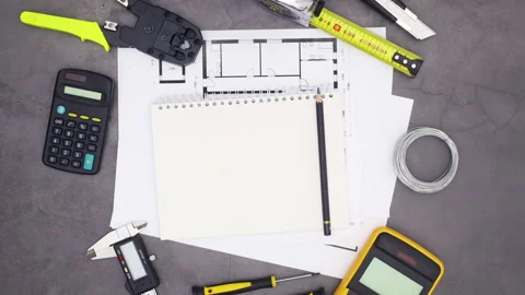 Building and construction tools moving around notebook with pencil. Stop motion Stock Footage 136917523