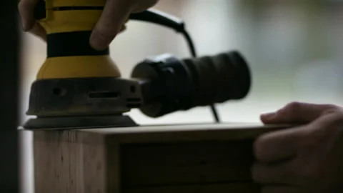 Building and construction. Working on a piece of wood with a power sander Stock Footage 130414218