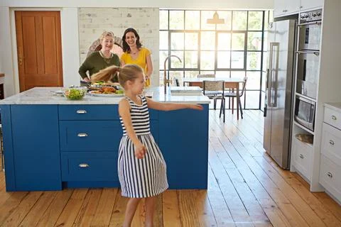 Building up an appetite. a little girl dancing while her mother and grandmother Stock Photos