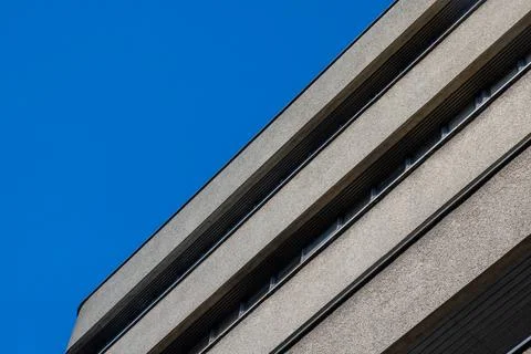 A building with bold horizontal lines and a blue sky in the background Stock Photos