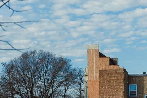 Building with brick structure and cloudy sky above in an urban area during .. Stock Photos