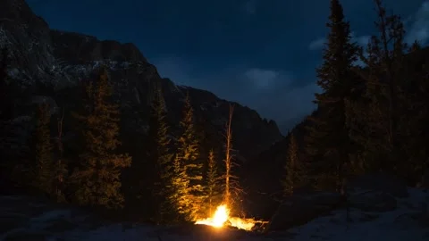 Building a camp fire in the mountains while it gets dark Stock Footage 310565352